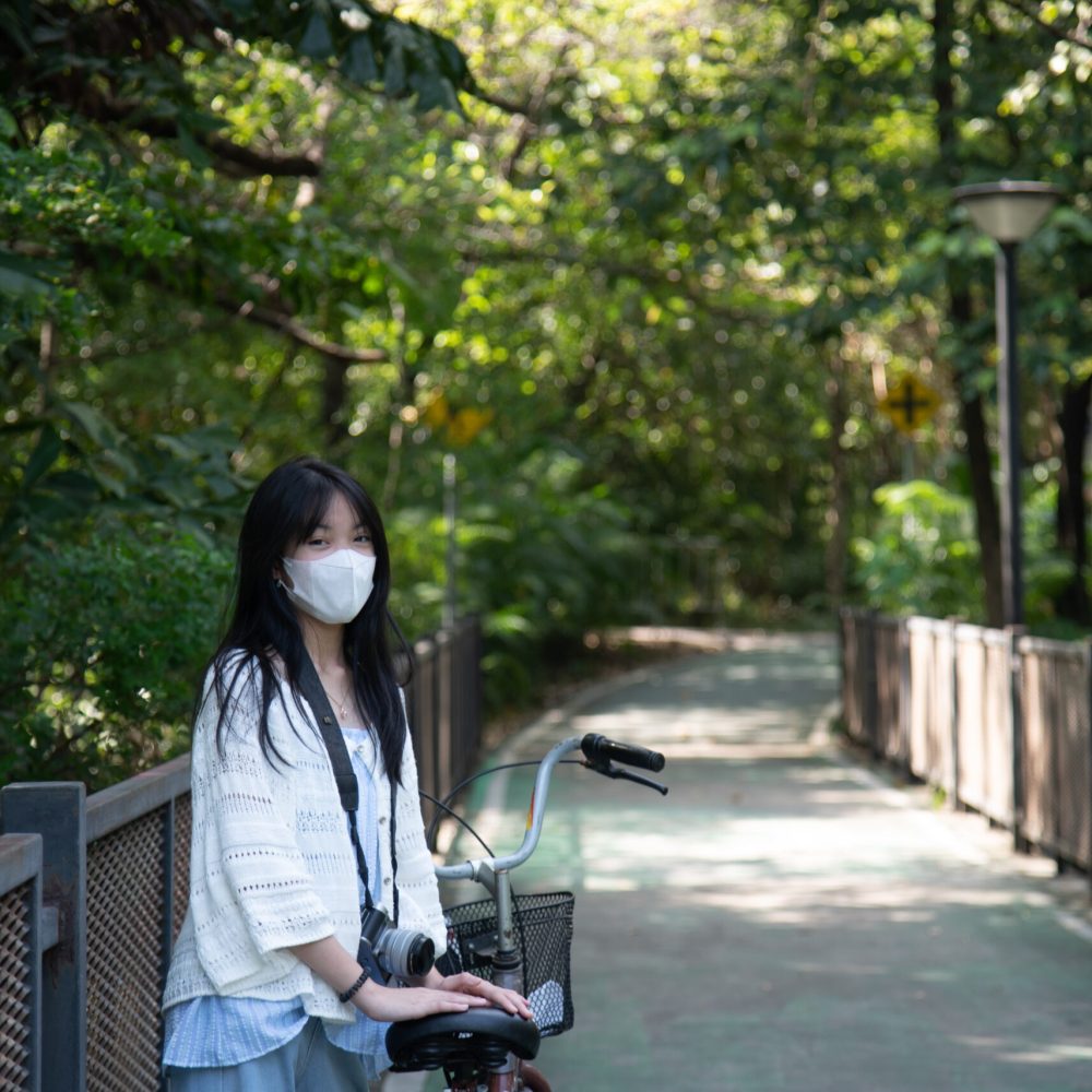 Asian woman riding a bicycle in the park.