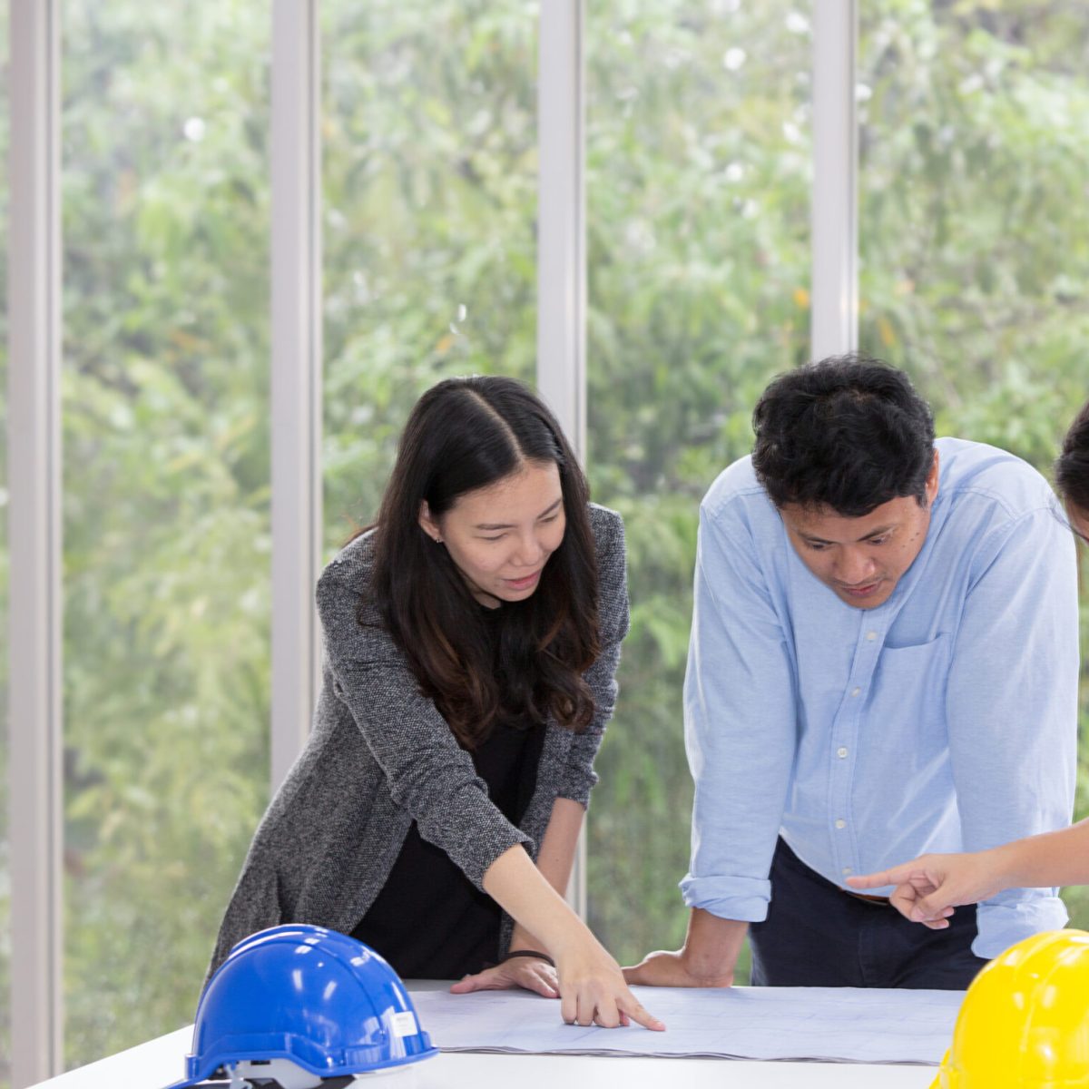 Three engineers working meeting room at the office. Three workers are talking construction plan. Electricians carpenter or Technical operaters and Labourers or Moving Operators. asian people.