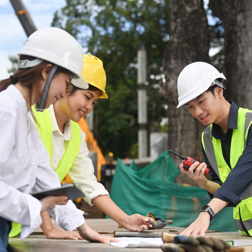 Team of specialists and Civil engineer inspecting industrial building construction site.